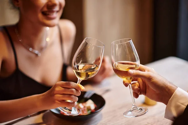 Happy couple clinking glasses of white wine during date on Valentines day, romantic dinner — Stock Photo