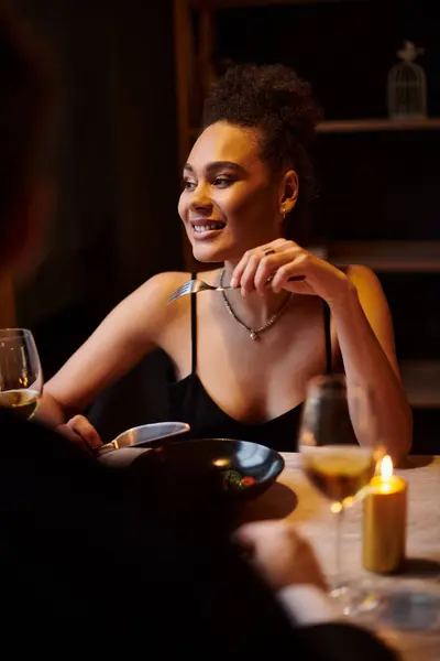 Joyeuse femme afro-américaine manger de la salade pendant la date avec petit ami au restaurant, Saint Valentin — Photo de stock