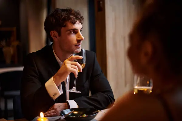 Handsome man holding glass of wine near girlfriend during date on Valentines day, romantic dinner — Stock Photo