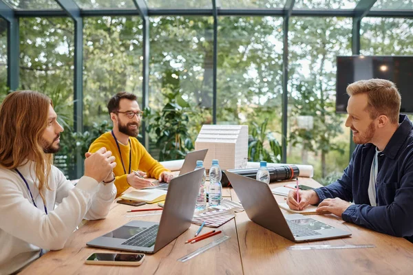 Joyful good looking businessmen in casual attire working attentively on their startup together — Stock Photo