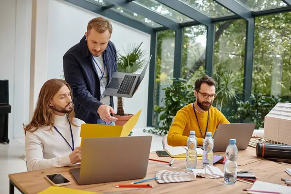 Glückliche, gut aussehende Geschäftsleute in legerer Kleidung, die gemeinsam aufmerksam an ihrem Start-up arbeiten — Stockfoto