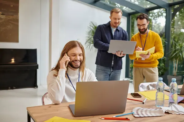 Happy attractive businessmen in casual outfit working attentively on their startup together — Stock Photo