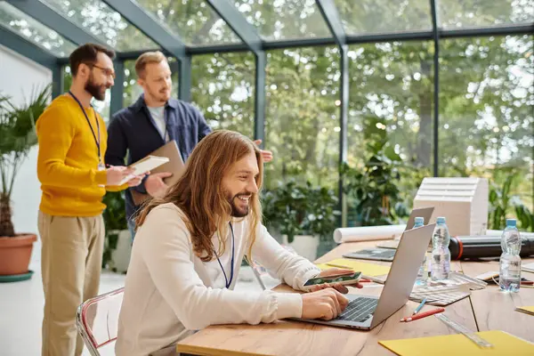 Merry appealing businessmen in casual outfit working attentively on their startup together — Stock Photo