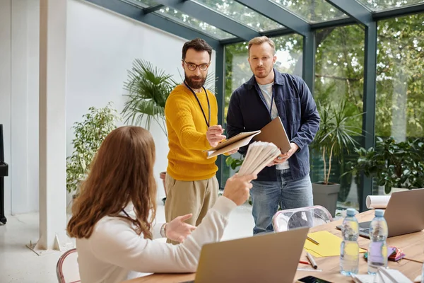 Arquitectos enfocados discutiendo su startup y revisando plantillas y borradores, concepto de negocio - foto de stock