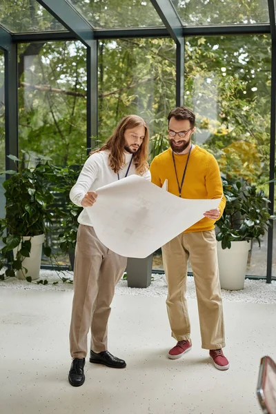 Cheerful man with glasses working with his handsome colleague with long hair, business concept — Stock Photo
