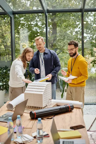 Gioiosi architetti belli in abiti casual che lavorano insieme sulla loro startup, concetto di coworking — Foto stock