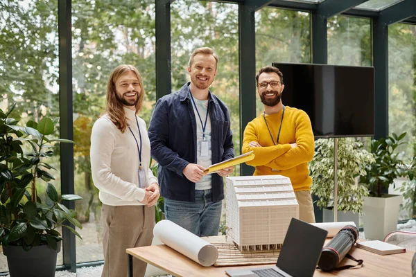 Fröhliche gutaussehende Architekten in lässigen Outfits arbeiten gemeinsam an ihrem Startup-Coworking-Konzept — Stockfoto