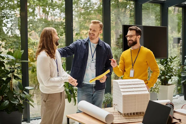 Glückliche gutaussehende Architekten in lässigen Outfits, die gemeinsam an ihrem Startup-Coworking-Konzept arbeiten — Stockfoto