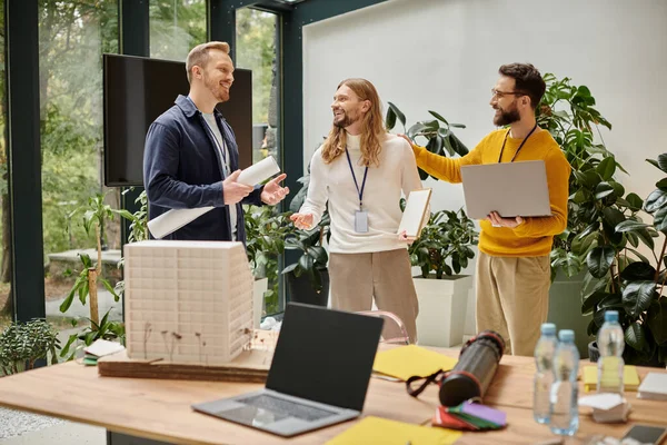Good looking happy architects in casual attires working together on their startup, coworking concept — Stock Photo