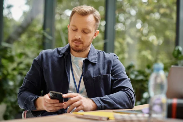 Attractive concentrated man in casual outfit working on his startup with his laptop in office — Stock Photo