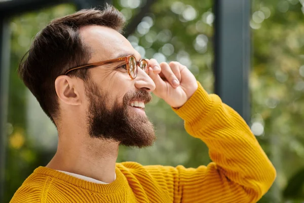 Cheerful handsome architect with glasses in yellow turtleneck posing in his office during work — Stock Photo