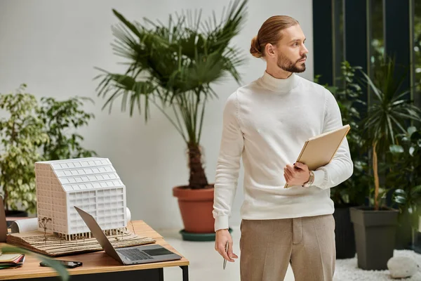 Focused attractive architect in white comfy turtleneck with beard holding his paperwork on startup — Stock Photo