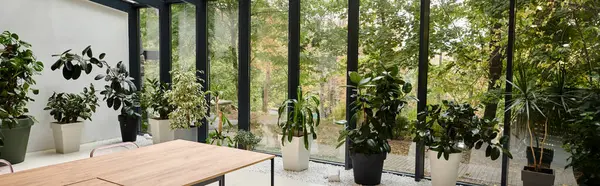 Foto interior de la moderna sala de reuniones minimalista con mesas y plantas verdes en macetas, pancarta - foto de stock