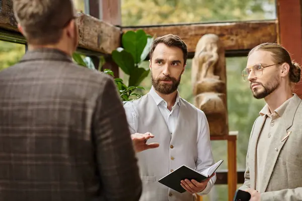 Handsome concentrated businessmen in elegant chic attires discussing their project in their office — Stock Photo