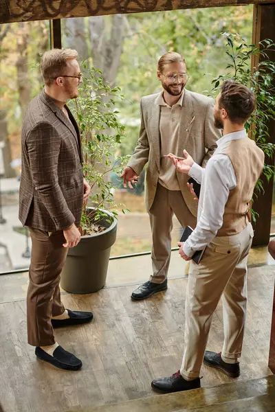 Joyeux beaux chefs d'entreprise avec des lunettes dans des tenues élégantes chic discuter de leur démarrage — Photo de stock