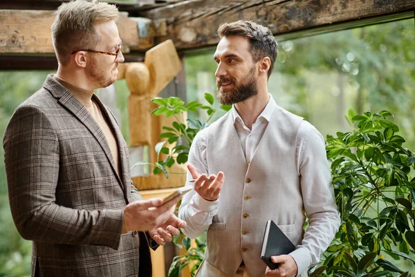 Joyeux chefs d'entreprise attrayants avec des lunettes dans des vêtements élégants discuter de leur démarrage — Photo de stock