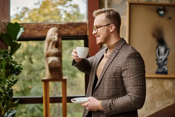 Líder de negócios sofisticado alegre com óculos no terno elegante que bebe seu café quente — Fotografia de Stock