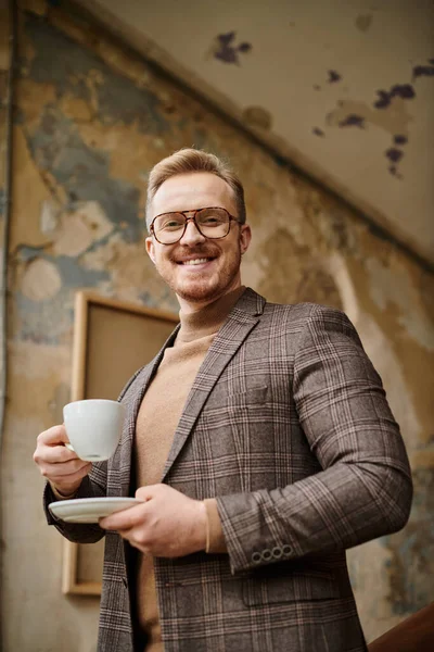 Merry sophisticated business leader with glasses in elegant chic suit drinking his hot coffee — Stock Photo