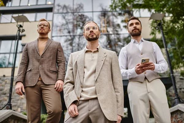 Konzentrierte gut aussehende Unternehmensführer in eleganten Anzügen posieren zusammen, während sie hart arbeiten — Stockfoto