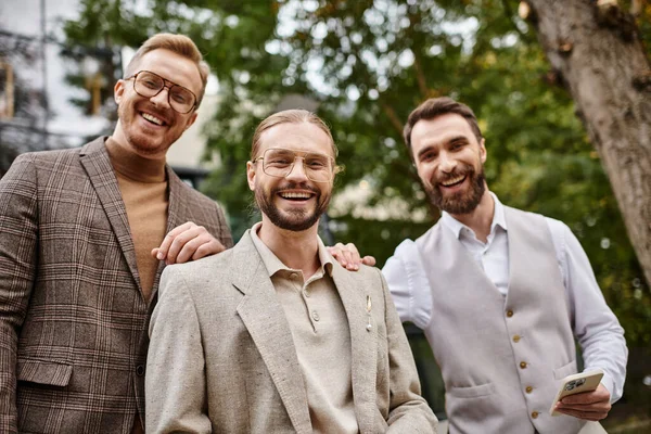 Joyeux chefs d'entreprise élégants avec des lunettes dans des vêtements sophistiqués discuter de leur démarrage — Photo de stock
