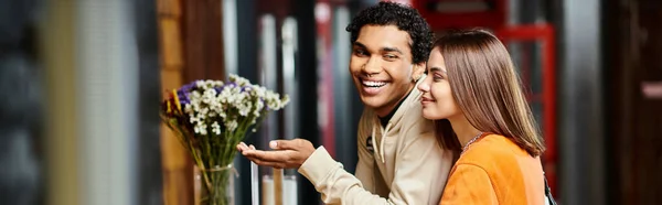 Glückliche junge Frau lächelt neben ihrem schwarzen Freund an der Rezeption des Hostels beim Check-in, Banner — Stockfoto