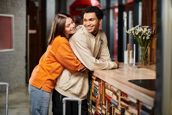Ein romantischer Moment zwischen einem Mann und einer Frau, als sie sich an der Rezeption im Hostel umarmen — Stockfoto