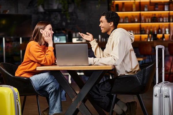 Diverse couple working on a project together, black man and woman sitting at table with a laptop — Stock Photo