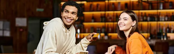 Banner of a cheerful black man with smartphone and credit card enjoying time with woman in a cafe — Stock Photo