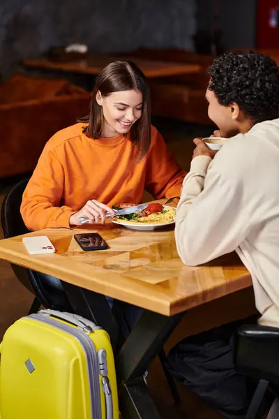 Homem negro e mulher compartilhando refeição, seus rostos refletindo contentamento em ambiente acolhedor interior — Fotografia de Stock