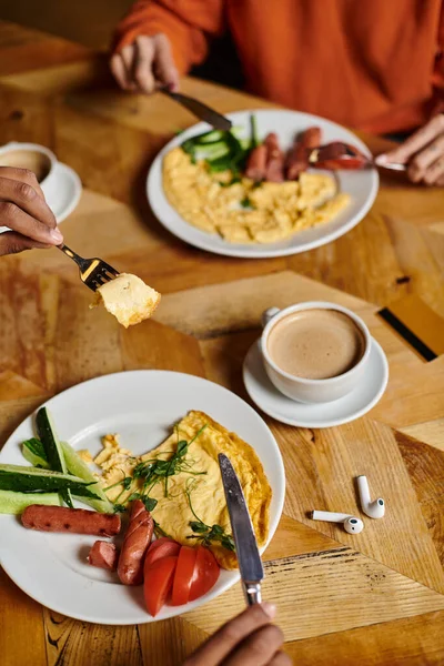 Se centran en el delicioso desayuno en el plato rodeado de vajilla taza de café en la mesa de madera rústica - foto de stock