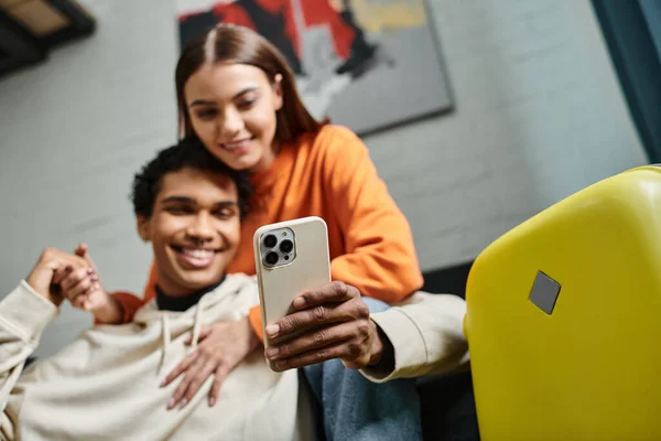 Focus on smartphone happy diverse couple browsing internet near luggage in hostel room — Stock Photo