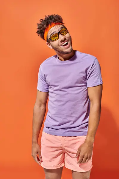 Excited young african american man in eyeglasses and casual attire on orange background, fella — Stock Photo
