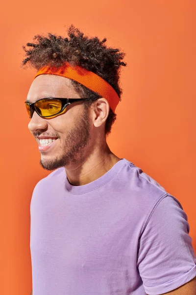 Glücklich afrikanisch-amerikanischer Fella in Brille, der auf orangefarbenem Hintergrund wegschaut, optimistischer Mann — Stockfoto