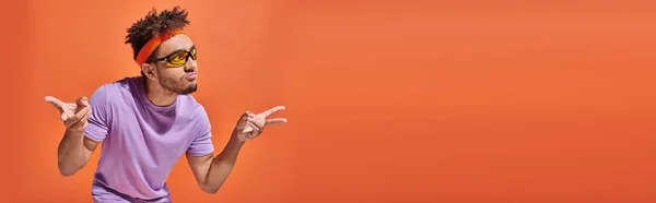 African american man in eyeglasses pouting lips and gesturing on orange background, banner — Stock Photo