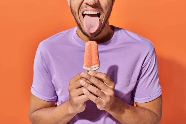 Hombre afroamericano cortado apestoso poner lengua y la celebración de helado con aspersiones - foto de stock