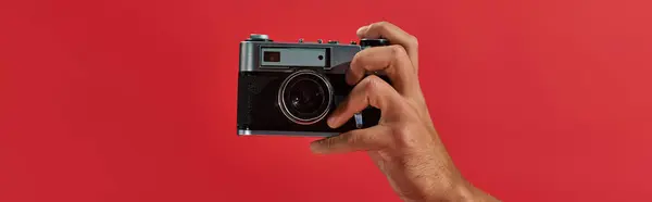 Обрізаний банер афроамериканського фотографа, який знімає ретро-камеру на червоному тлі — стокове фото