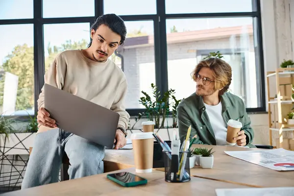 Two young businessmen focused on a project near laptop in office — Stock Photo