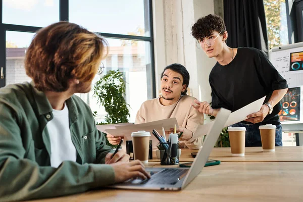 Team of young entrepreneurs engaged in project planning at a bright office, blurred man near laptop — Stock Photo