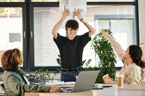 Jovem gerente feliz em hir 20s apresentando gráficos durante reunião com sua equipe de inicialização, brainstorming — Fotografia de Stock