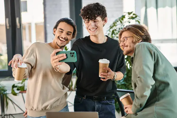 Hommes d'affaires heureux profitant d'une pause café et de prendre un selfie dans un espace de coworking, les hommes dans les années 20 — Photo de stock