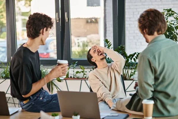 Cheerful team member expressing genuine emotion during a coffee break at the office, startup — Stock Photo