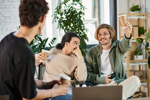 Jóvenes alegres en sus 20s charlando durante el descanso de café en la oficina, el éxito de la puesta en marcha - foto de stock