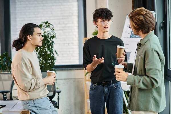 Jovens colegas de trabalho na casa dos 20 anos compartilhando ideias sobre café em um ambiente de escritório moderno, equipe de inicialização — Fotografia de Stock