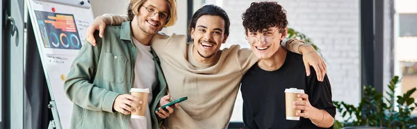 Banner of ambitious young men, three joyful startup team bonding over coffee in office environment — Stock Photo