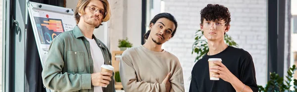 Ambitious young men looking at camera banner, three startup team members with coffee to go — Stock Photo