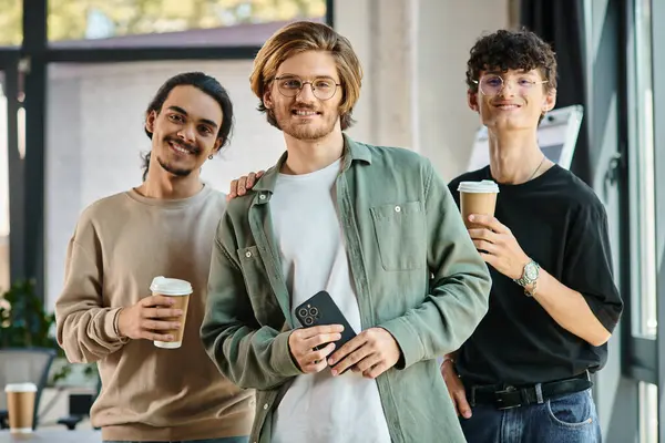 Trois jeunes hommes d'une vingtaine d'années avec café dans une ambiance de bureau conviviale, headshot professionnel — Photo de stock