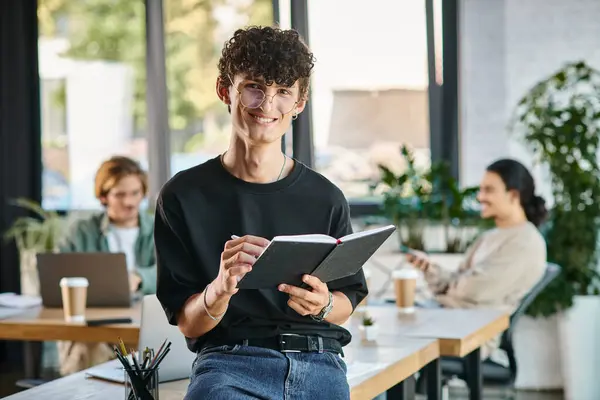 Glücklicher und lockiger Mann, der in einem dynamischen Büroraum lächelt und Notizen macht, Startup-Ideen — Stockfoto