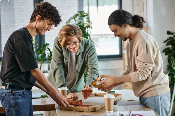 Young men enjoying a pizza lunch break in a friendly and relaxed office atmosphere, startup team — Stock Photo