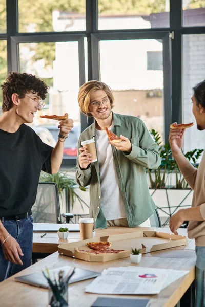 Happy men enjoying a pizza lunch break in a friendly and relaxed office atmosphere, startup team — Stock Photo