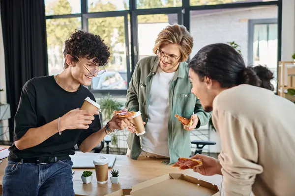 Hommes souriants dégustant une pizza dans une atmosphère conviviale et détendue, équipe de démarrage ayant pause déjeuner — Photo de stock